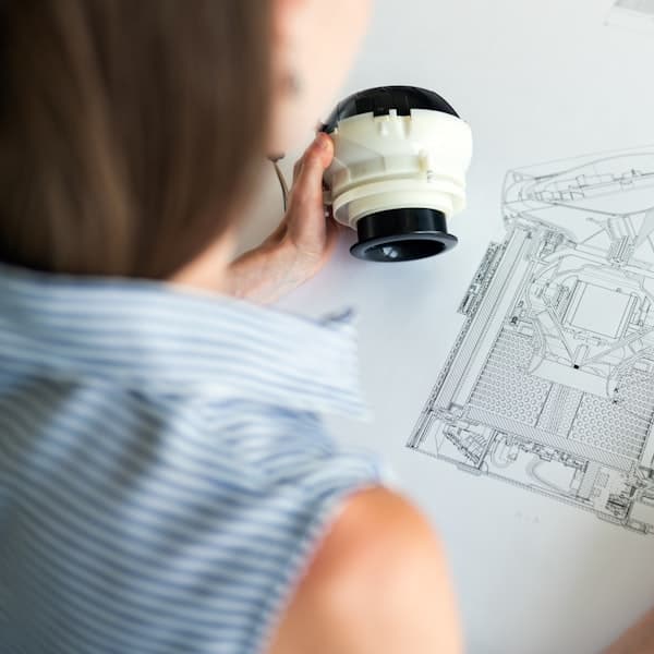 Engineering drawings and measuring tools on a bench